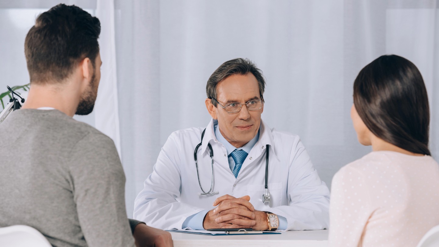 Doctor providing trauma-informed care to a young couple in a clinic
